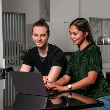 Young couple looking at a computer at home.