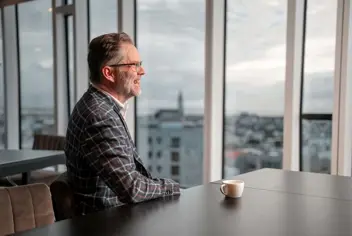 Maður með kaffibolla á skrifstofu.
